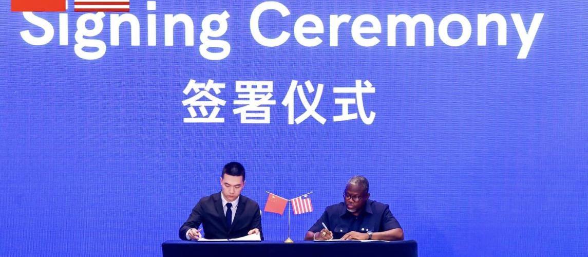 Mr. Zheng Xudong of the Shanghai Black Rock Lake Enterprise Development Company and Liberia's Information Minister Jerolinmek Piah at the signing ceremony